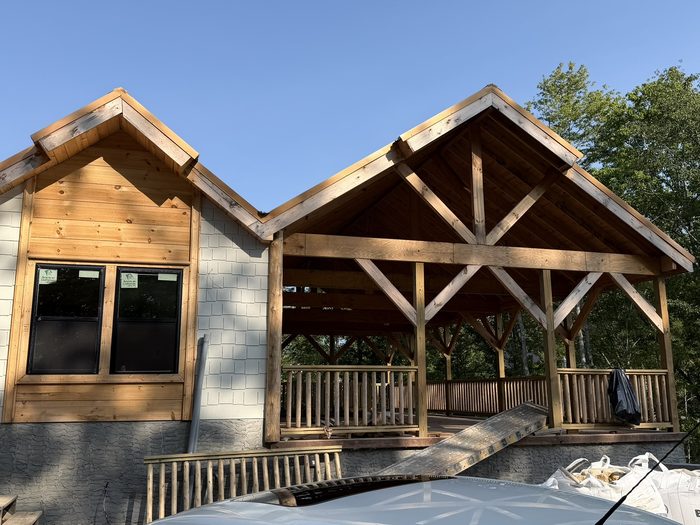 Twin timber-frame gables with exposed trusses over covered porches.